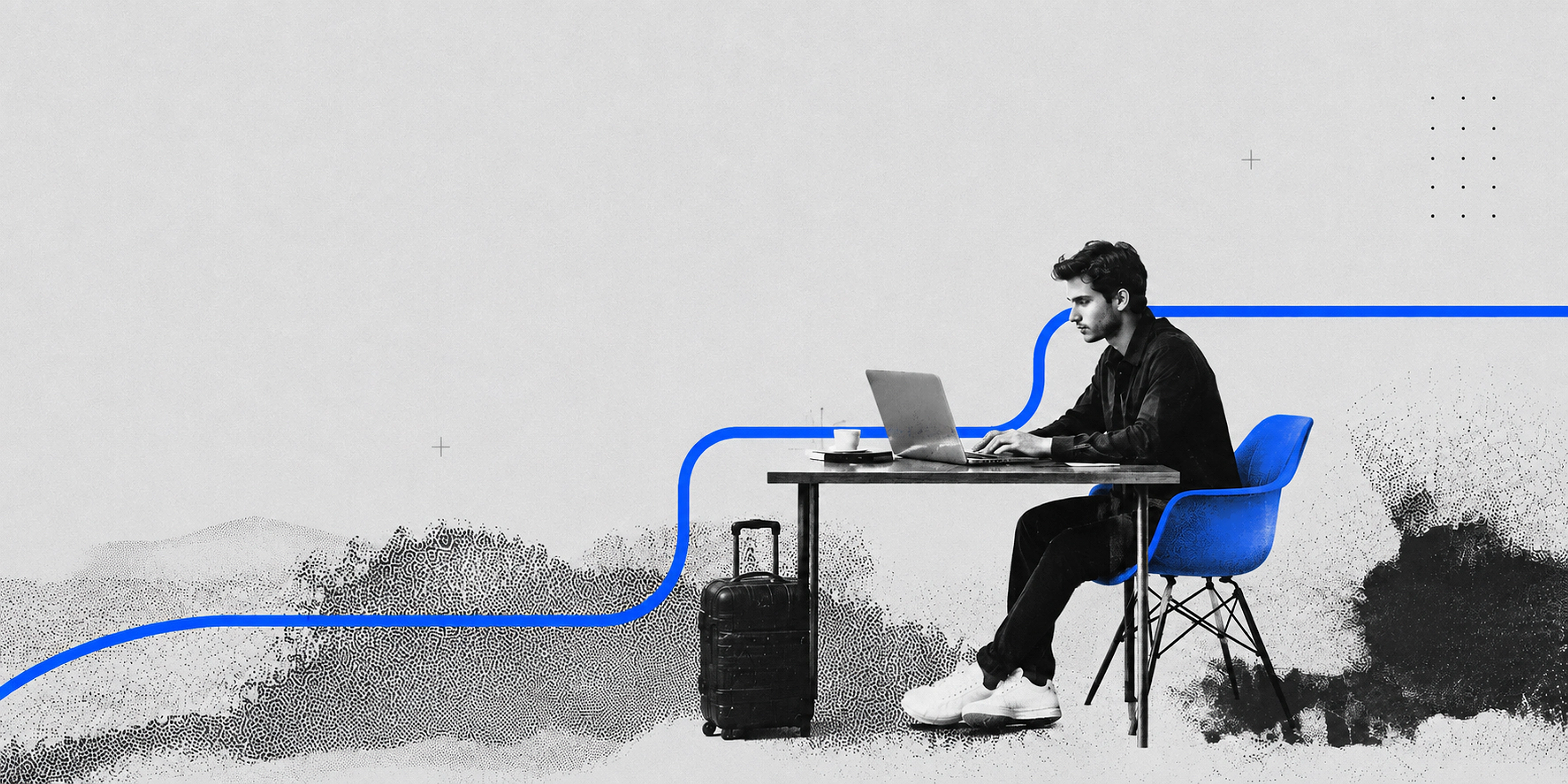 Travel agent working at a laptop beside a suitcase.